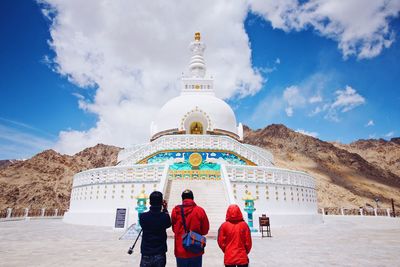 People in front of temple against sky