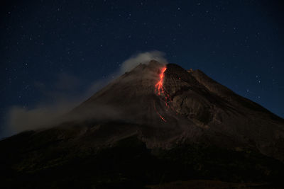 Scenic view of volcanic mountain against sky at night