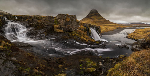 Scenic view of waterfall against sky