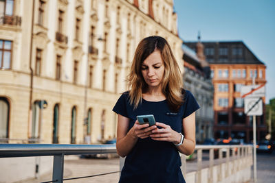 Woman using smartphone at city street