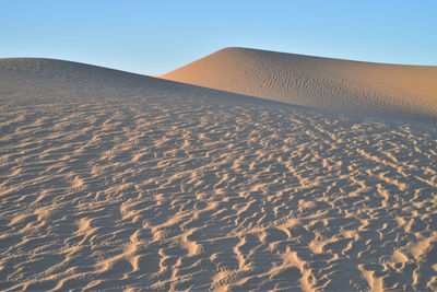 Scenic view of desert against clear blue sky