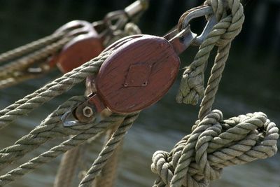 Ropes attached to wooden pulleys against lake