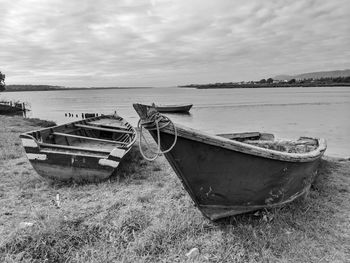 Boats moored at shore against sky