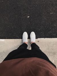 Low section of man standing on road