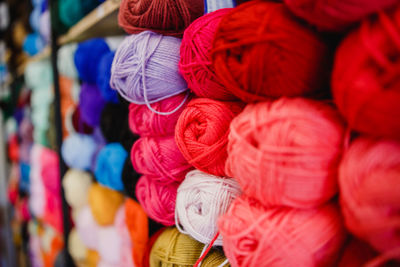 Full frame shot of multi colored woolen balls on shelf at shop