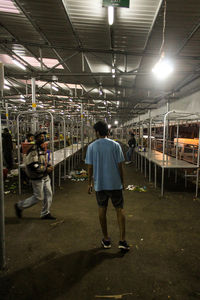 Rear view of man and woman walking in illuminated street