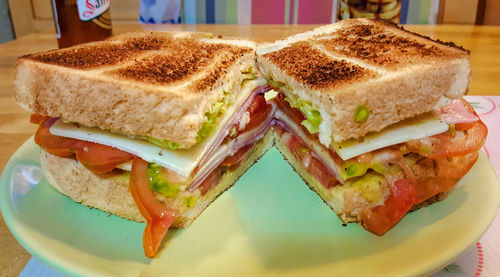 Close-up of ham cheese sandwiches served in plate on table