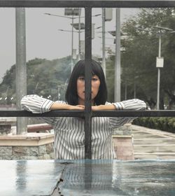 Portrait of woman against railing