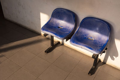 High angle view of empty chair against wall