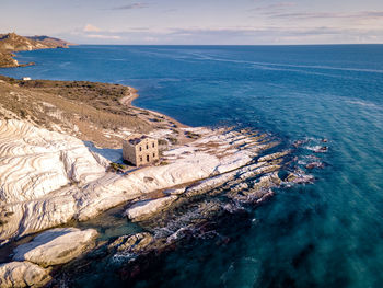 High angle view of rock formation in sea against sky