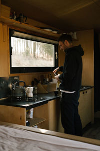 Rear view of man working in kitchen