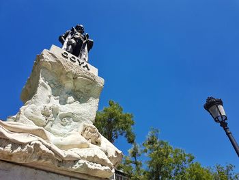 Low angle view of statue against clear blue sky