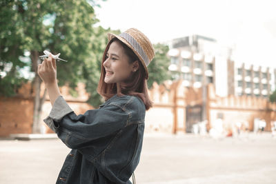 Young woman using smart phone in city