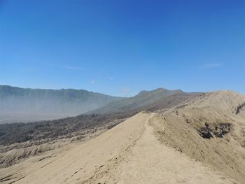 Scenic view of desert against blue sky