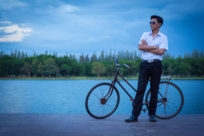 Man riding bicycle on water against sky