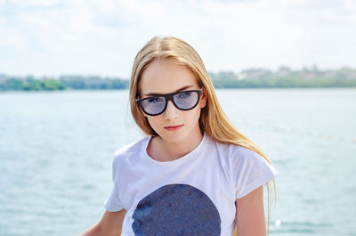 Portrait of teenage girl standing by sea