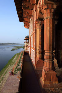 Agra fort by lake against clear sky