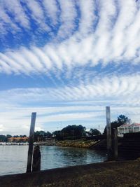 Bridge over river against sky in city