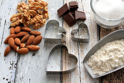 High angle view of almonds with chocolates and pastry cutters on table