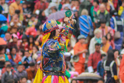 Side view of male artist in colorful traditional clothing performing against audience
