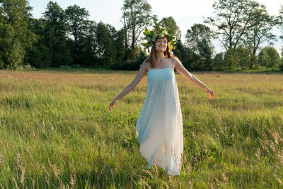 Woman dance ecstatic dance in field. woman in flower wreath. summer solstice day.