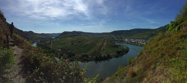 Scenic view of river by mountains against sky