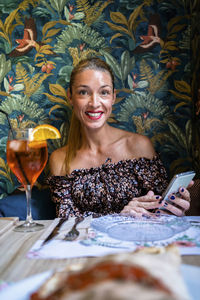 Portrait of a smiling young woman holding drink