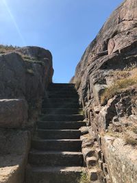 Low angle view of steps leading towards mountain against sky