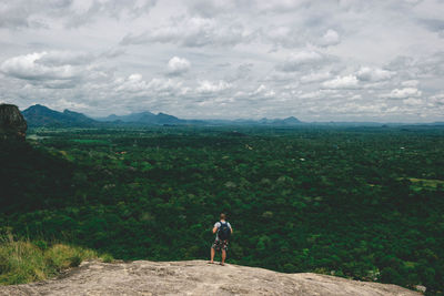 Rear view of woman looking at mountain against sky