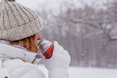 Portrait of woman with hat on snow