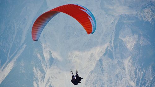 Person paragliding over mountain