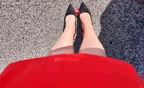 Low section of woman standing on road