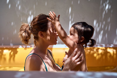 Young mother in an inflatable pool with her little daughter. concept holidays