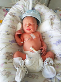 High angle view of cute baby lying on bed