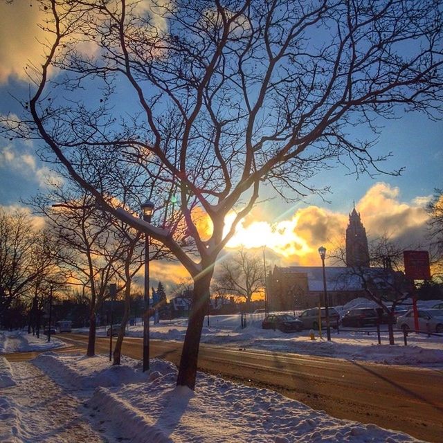 snow, winter, cold temperature, bare tree, sunset, season, sky, tree, weather, built structure, covering, nature, branch, architecture, building exterior, cloud - sky, orange color, frozen, tranquility, sun