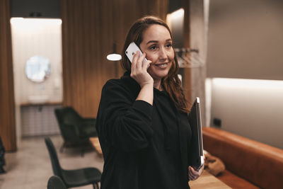 Portrait of smiling young woman using smart phone