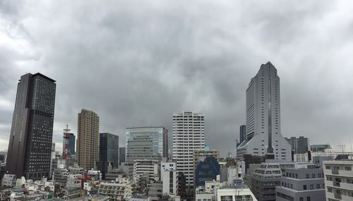 Buildings in city against cloudy sky