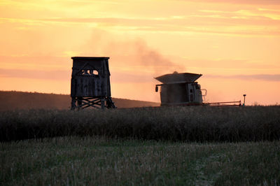 Built structure on field against sky during sunset