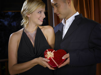 Close-up of couple holding gift while standing in ceremony