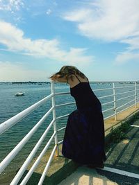 Rear view of woman on sea shore against sky
