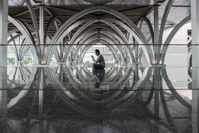 Man standing by glass window