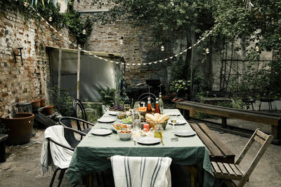 Food and drink arranged on dining table in empty back yard