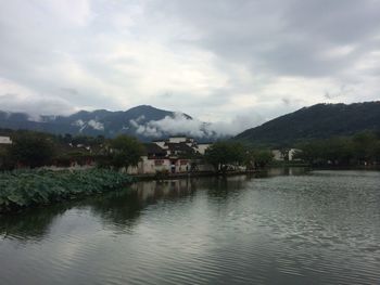 Scenic view of river and mountains against cloudy sky