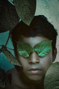 Directly above shot of boy with leaves on eyes