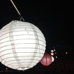 Low angle view of illuminated lamp hanging at night