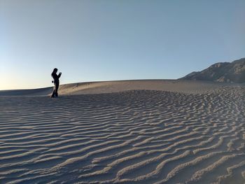 Mid distance view of woman standing at desert in death valley national park