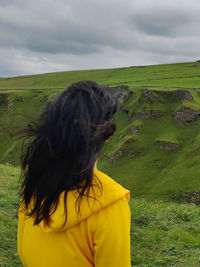 Rear view of woman against yellow sky