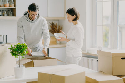 Couple holding plates in kitchen