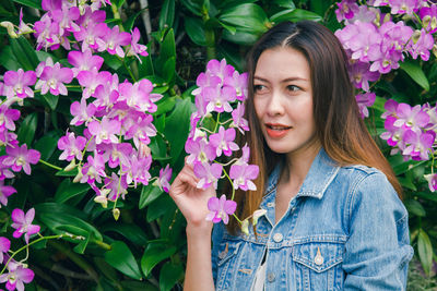 Portrait of beautiful woman with pink flower