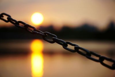 Close-up of chain against sky during sunset